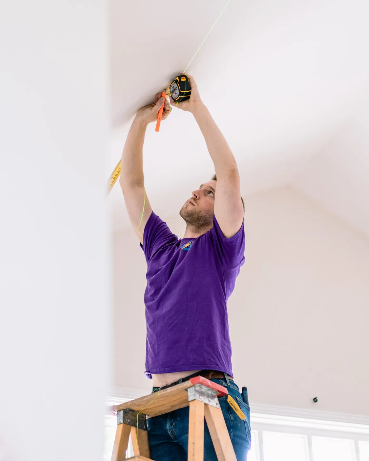 Paul marking ceiling positions before electrical fixture installation