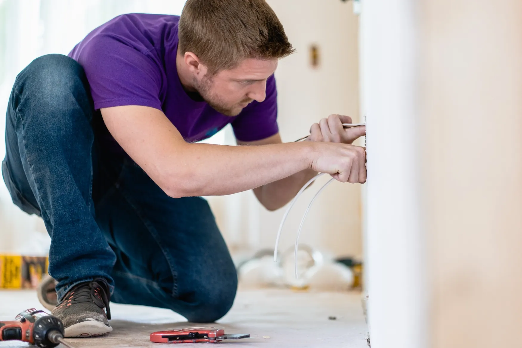 Paul working on wall wiring during an electrical installation